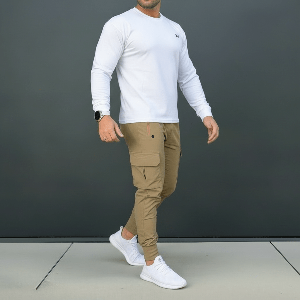 Man wearing a white long-sleeve shirt, beige cargo pants, and white sneakers against a dark gray background.
