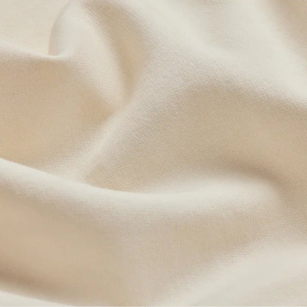 close up view of a cream colored hoodie to show the fabric softness