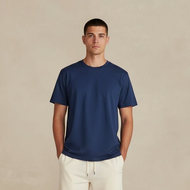 Person wearing a blue shirt and white pants against a beige background