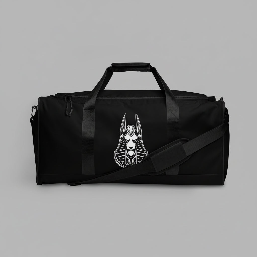 A black duffle bag with a logo on the front, featuring a padded shoulder strap and a zipper closure.