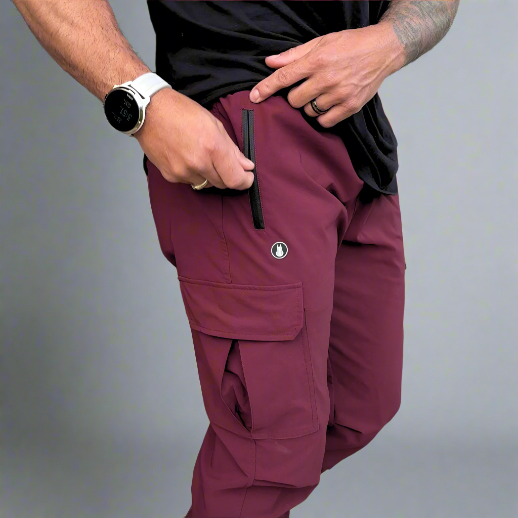 Person wearing maroon cargo pants with a gray background