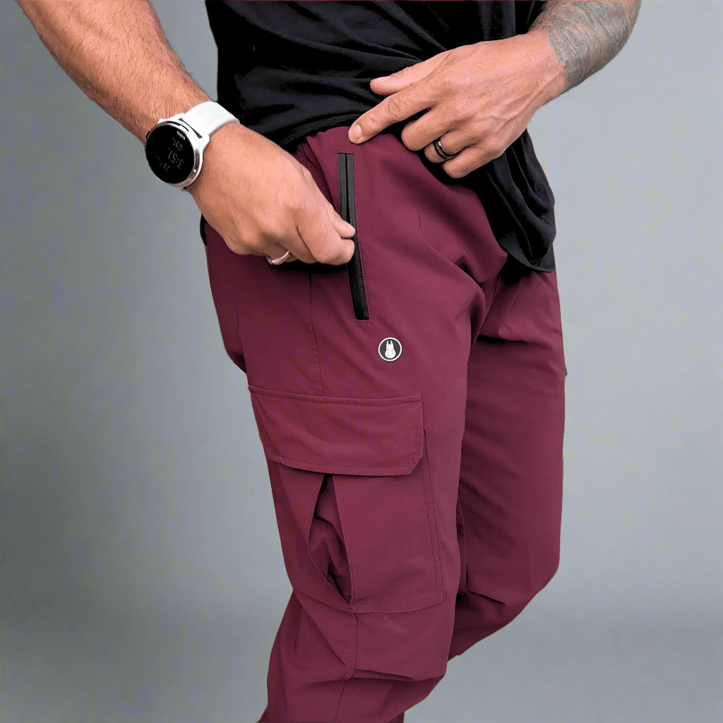 Person wearing maroon cargo pants with a gray background