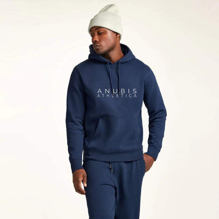 Man with Blue Anubis Athletica Hoodie, matching sweat pants and cream colored beanie on.