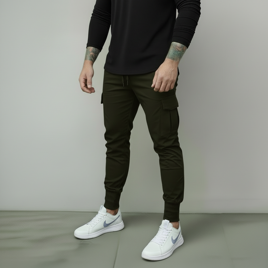 Person wearing dark green cargo pants and white sneakers on a plain background