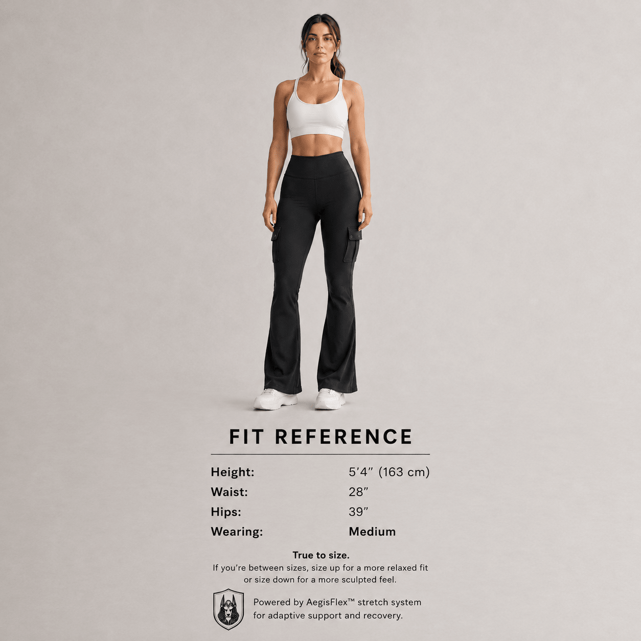 A woman stands against a light gray studio background wearing black wide-leg athletic pants and a white sports bra. Below the model, a fit reference table lists height, waist, hips, and wearing size, with text noting the product is powered by AngiFiase stretch system.