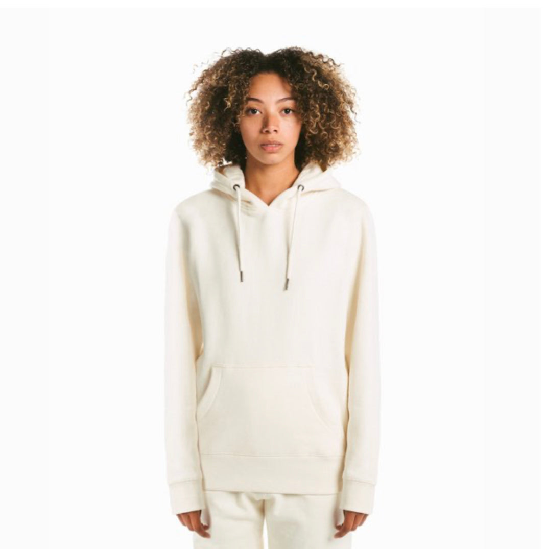 a black female model wearing a cream colored pull over hoodie and a pair of matching sweatpants.