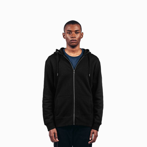 a black male model wearing a black zip up hoodie and matching pants in front of a white background