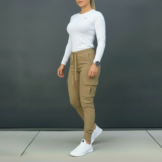 Person wearing a white long-sleeve top and beige pants against a dark background