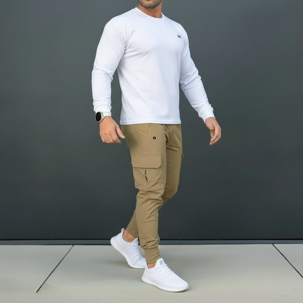 Man wearing a white long-sleeve shirt, beige cargo pants, and white sneakers against a dark gray background.