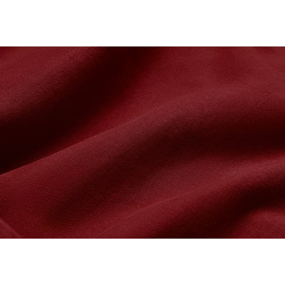 a close up view of the fabric of an oxblood red hoodie showing the softness