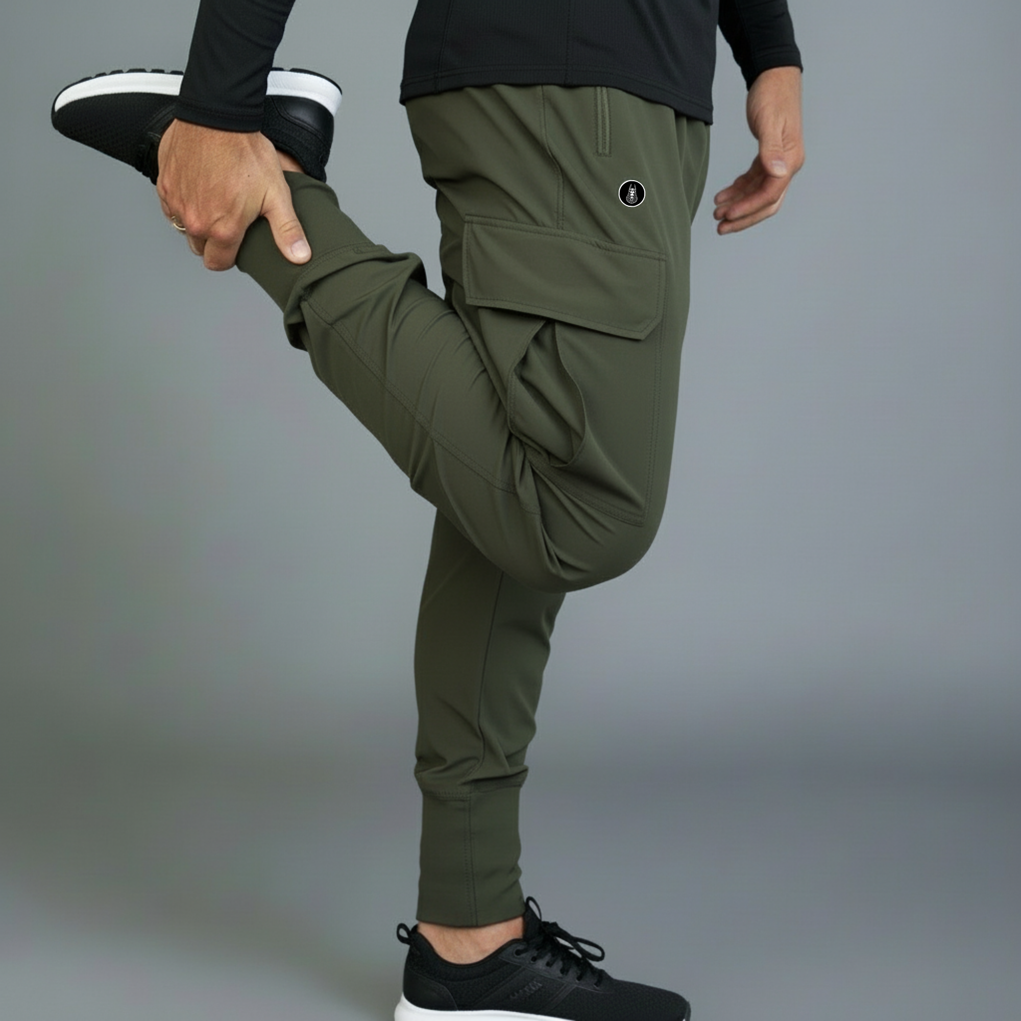 Person wearing green jogger pants and black sneakers on a gray background