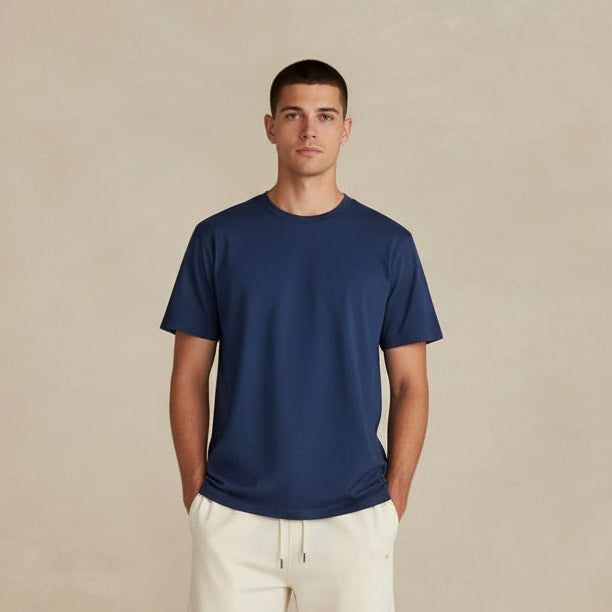 Person wearing a blue shirt and white pants against a beige background