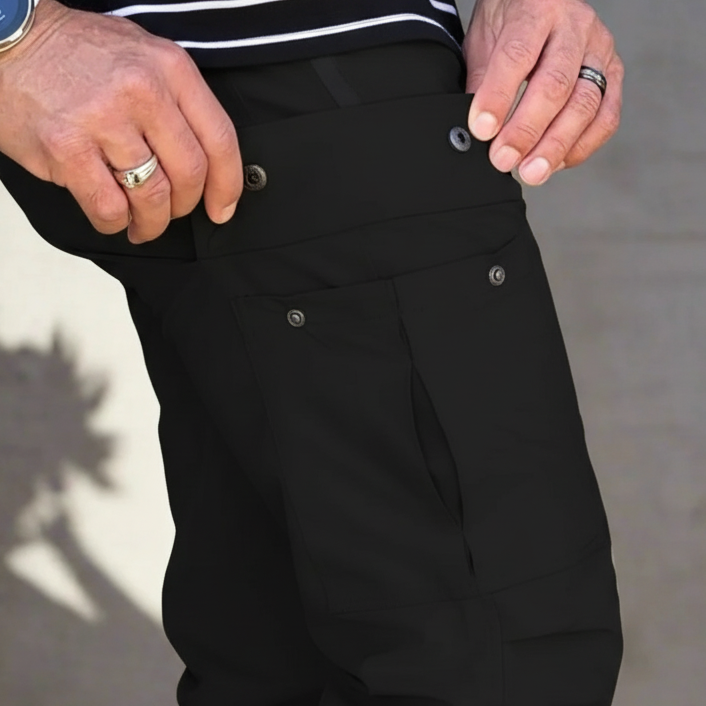Person wearing black pants with a neutral background