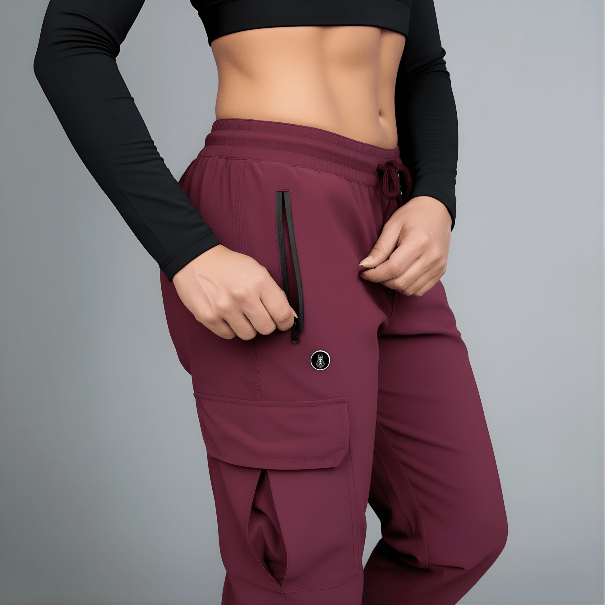 Maroon pants with a black zipper and logo on a gray background