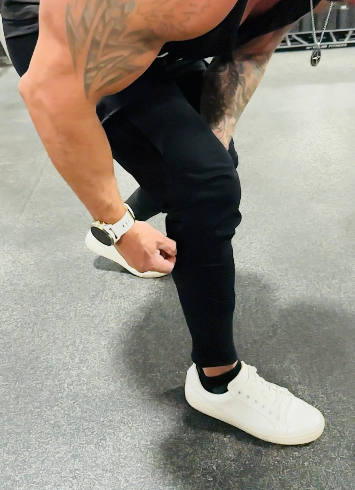 male model wearing black cargo joggers in the gym