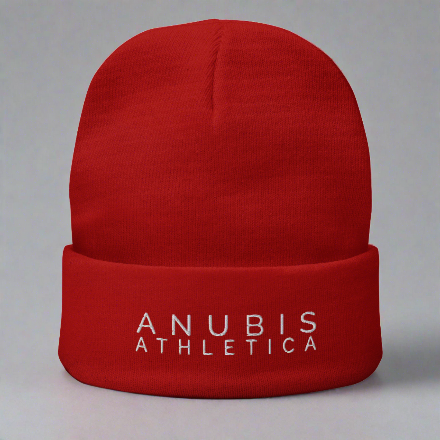 Knit beanie with the words Anubis Athletica embroidered on the front . Beanie color is red