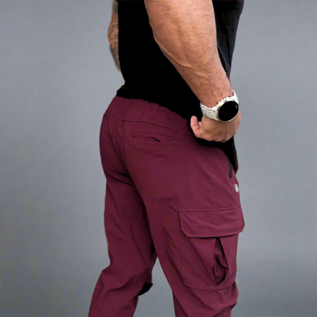 Person wearing maroon cargo pants with a gray background