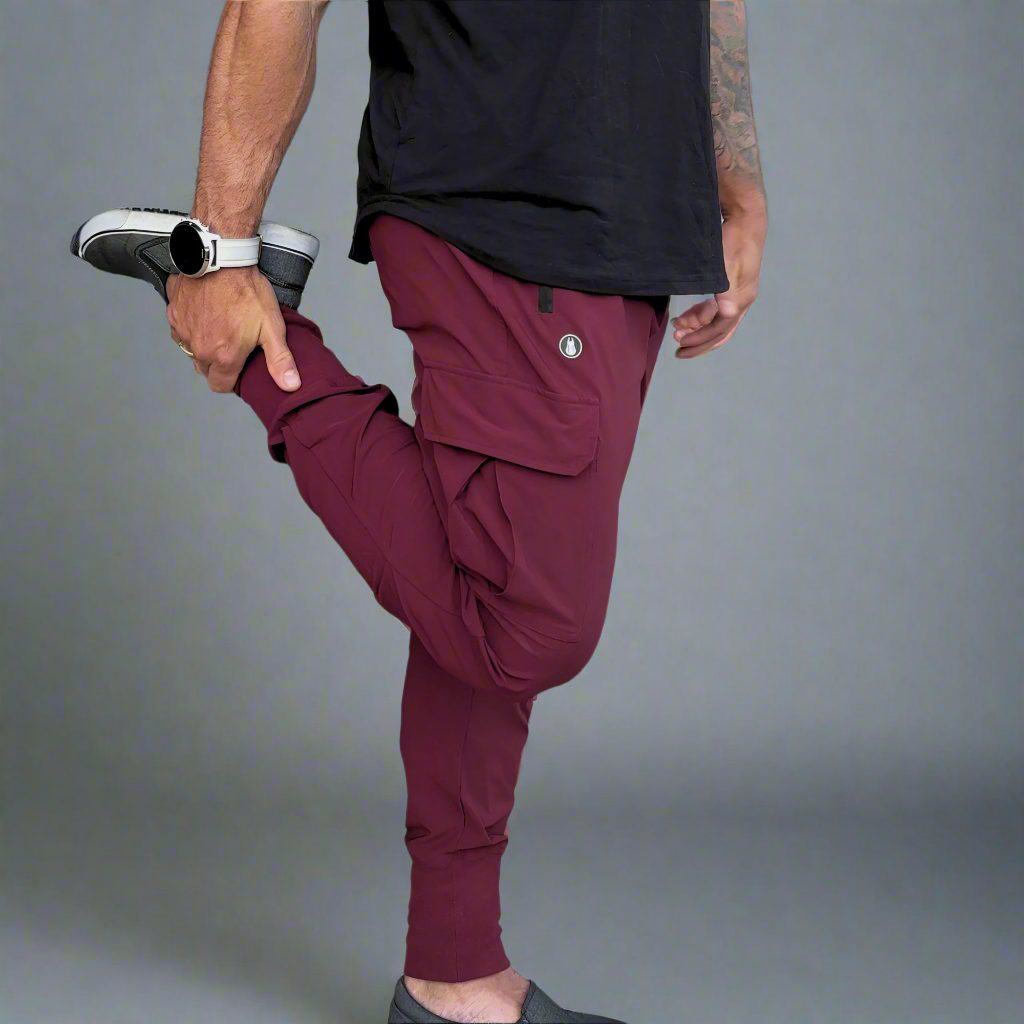 Person wearing maroon jogger pants and black shirt on a gray background