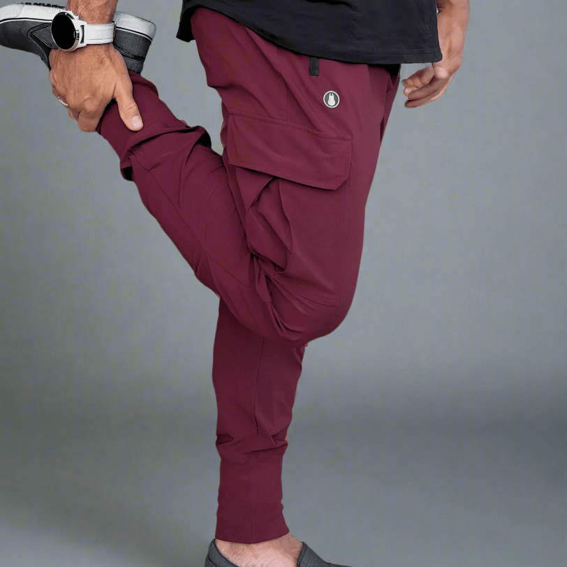 Person wearing maroon jogger pants and black shirt on a gray background