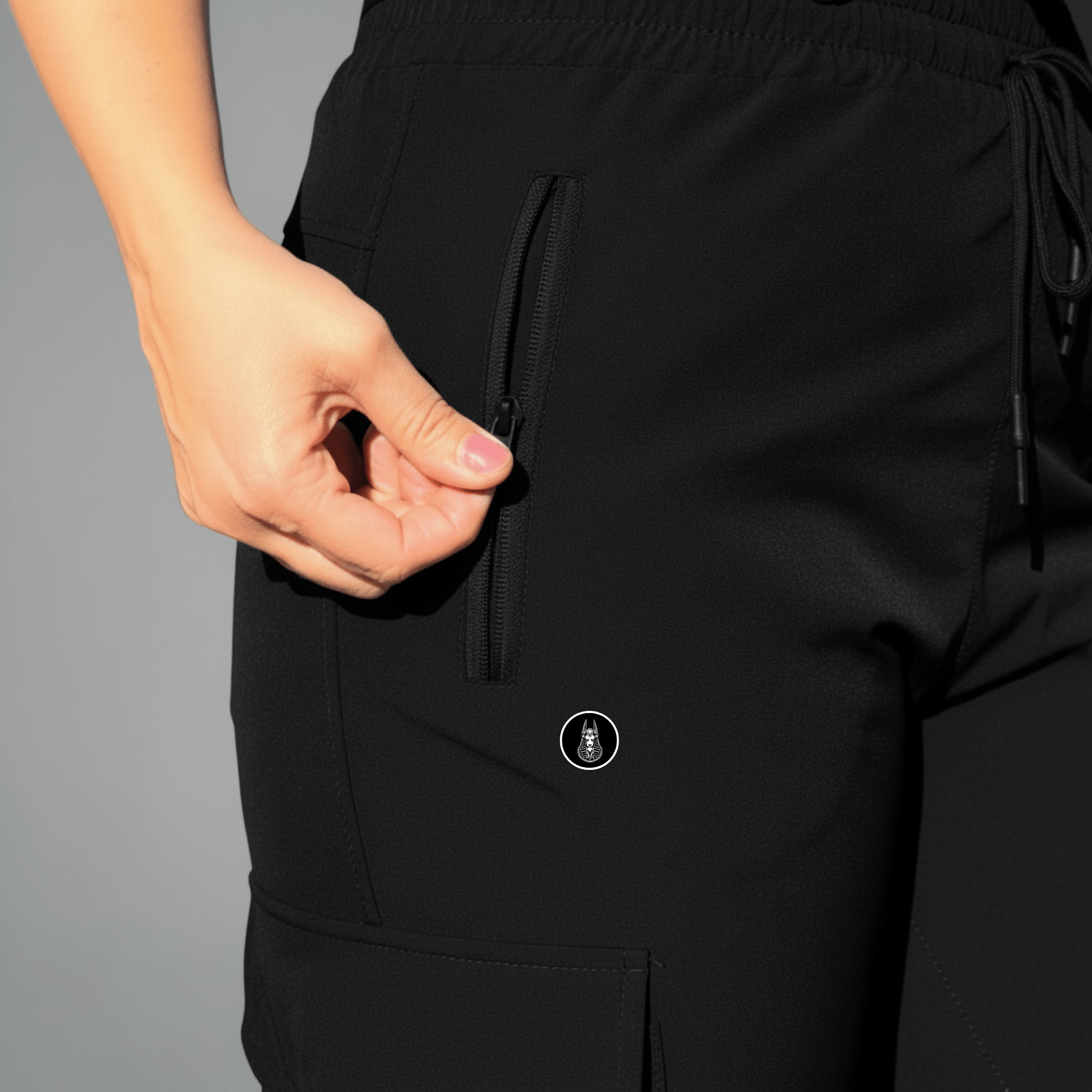 Black pants with a brand logo on a gray background